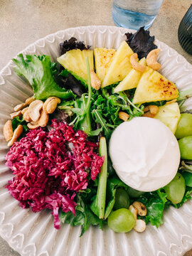 Fresh salad plate with pineapple, grapes, greens and cheese
