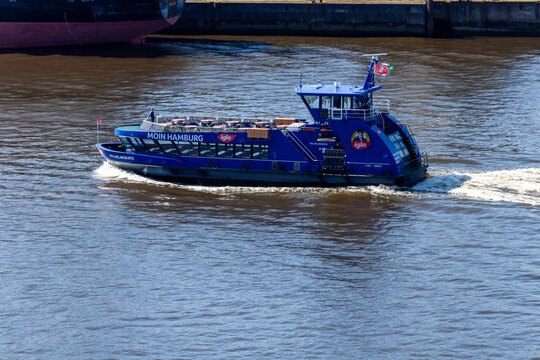 HADAG ferry "Wilhelmsburg" with "Moin Hamburg" and "Iglo" branding cruising on the Elbe River. Modern passenger water transport in the Port of Hamburg, Germany