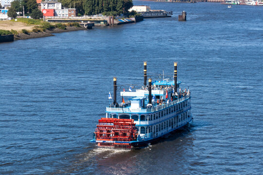 The iconic paddle steamer Louisiana Star cruising on the Elbe River in Hamburg. Traditional Mississippi-style riverboat for harbor tours and events on a sunny day. Hamburg, Germany