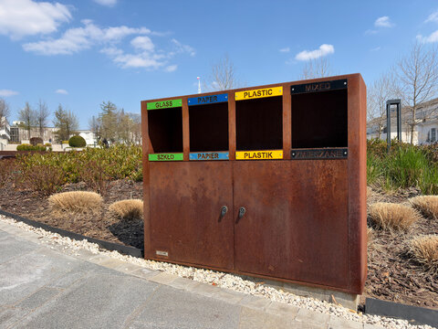Public Waste Collection Containers Positioned Outside Houses With Colorful Trims And Sustainability Signage