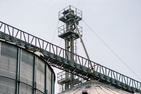 View of the metallic grain elevator complex against a bright sky, showcasing industrial architecture and agricultural storage, Sremska Mitrovica, Vojvodina, Serbia.