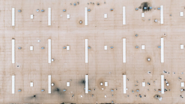 Aerial view of a patterned landscape with long white lines and dark spots creates a stark geometric contrast from above, Sremska Mitrovica, Vojvodina, Serbia.