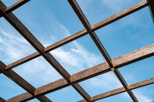 Wooden Roof Frame Structure Against Blue Sky Background