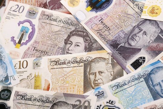 British pound money bills pile on table. United Kingdom banknotes of GBP currency close up.