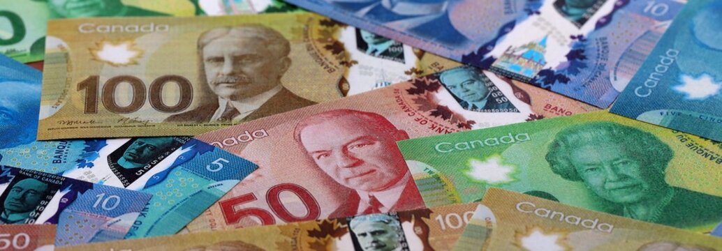 Canadian dollar money bills pile on table. Canada banknotes of CAD currency close up.