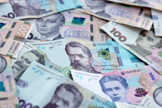 Ukrainian hryvnia money bills pile on table. Ukraine banknotes of UAH currency close up.