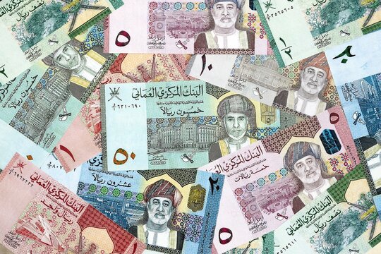 Omani rial money bills pile on table. Oman banknotes of OMR currency close up.