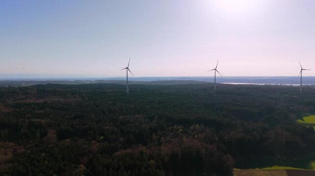 Panoramic aerial view of windmills and wind towers near Starnberg in Bavaria. Renewable energy infrastructure in countryside with turbines generating clean electricity.