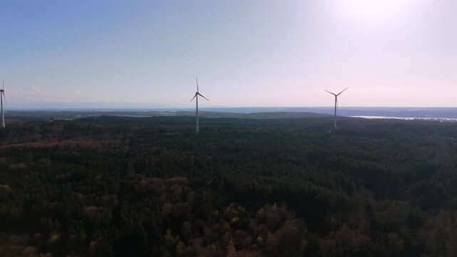 Drohnenaufnahme eines Windkraftwerks nahe Muenchen und Starnberg. Moderne Windturbinen und Rotoren in Feldern und Wald, nachhaltige Energiegewinnung.