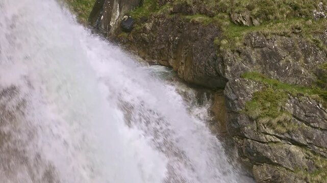 Closeup view on a mountain waterfall with water cascading down from rocky cliffs. Staeuberfall waterfall, Switzerland.