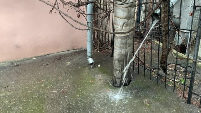 Rainwater flows down drainpipes during a downpour in the old town.