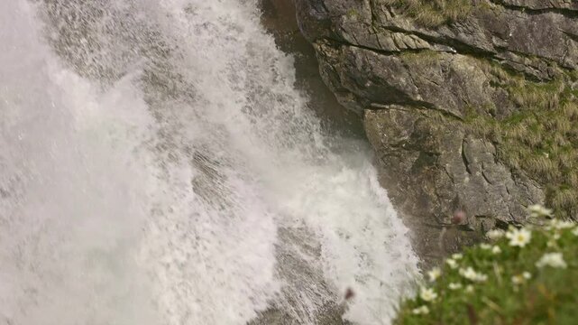 Closeup view on a mountain waterfall with water cascading down from rocky cliffs. Staeuberfall waterfall, Switzerland.