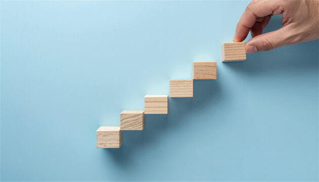 man hand placing wooden block to complete stair. Business growth and development concept. Career ladder, building success and strategy. Minimalist visual representation of achievement
