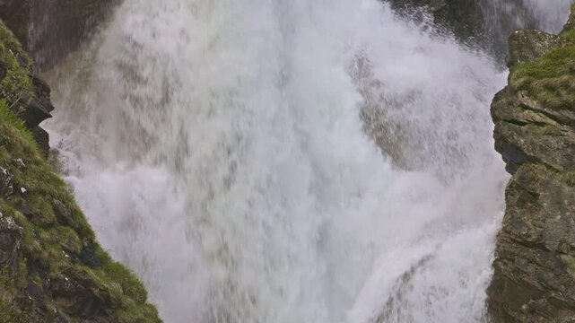 Closeup view on a mountain waterfall with water cascading down from rocky cliffs. Staeuberfall waterfall, Switzerland.
