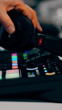 Hand adjusting dial audio mixer podcast equipment vertical video. Sound engineer regulating volume levels professional broadcasting hardware. Content creator working modern recording studio