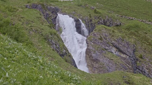 A mountain waterfall with water cascading down from rocky cliffs. Staeuberfall waterfall, Switzerland.