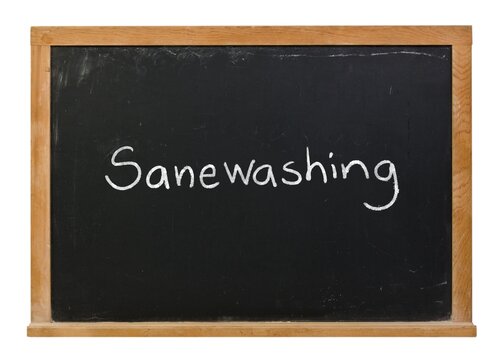 Sanewashing written in white chalk on a black chalkboard in a wooden frame isolated on white