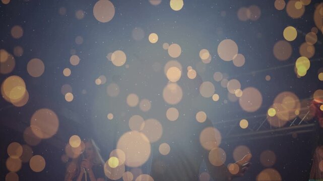 Male lead singer singing at concert with mic bokeh appearing then clearing revealing band for vibe