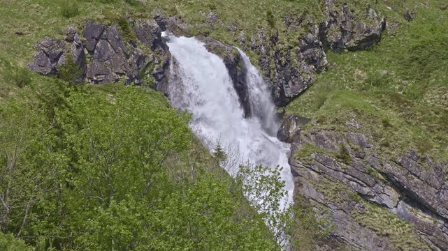 A mountain waterfall with water cascading down from rocky cliffs. Staeuberfall waterfall, Switzerland.