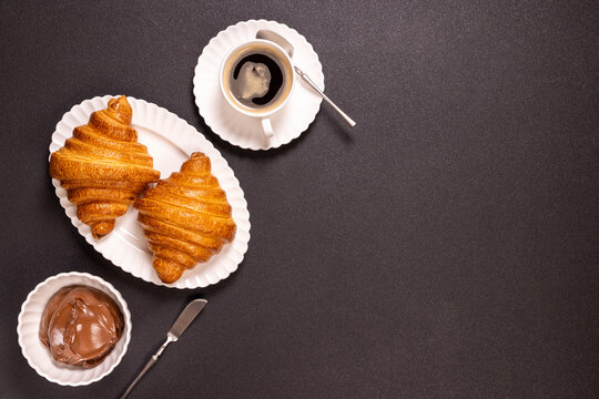 Croissants with chocolate spread and coffee for breakfast