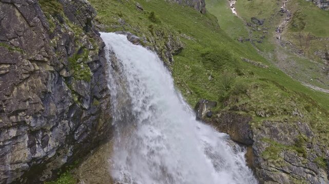 A mountain waterfall with water cascading down from rocky cliffs. Staeuberfall waterfall, Switzerland.