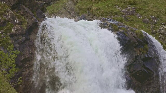 A mountain waterfall with water cascading down from rocky cliffs. Staeuberfall waterfall, Switzerland.