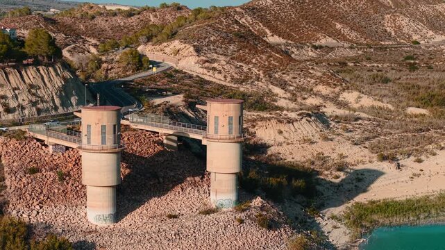 Aerial view of motorcyclist riding near la pedrera reservoir dam in murcia spain