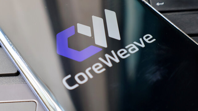 A close-up view of a laptop screen displaying the CoreWeave logo prominently