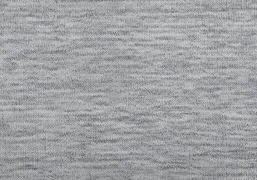 Detailed close up of a grey marl knitted fabric texture with visible stitches and fibers