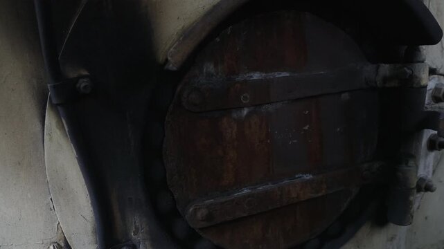 Detail of opening and closing the coal firebox door of a vintage steam locomotive. Glowing fire inside the furnace, historic engine, 4K, ProRes, 50fps.