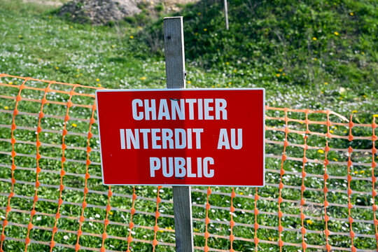 French construction site warning sign "Chantier Interdit au Public" on a fence.