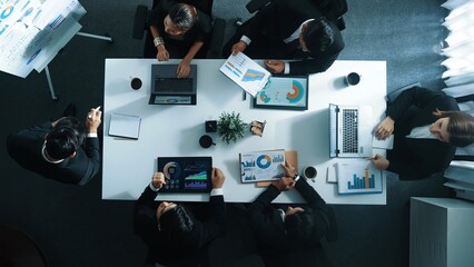 Top down aerial view of manager standing and present business plan to skilled investor. Business team working together to analyze financial statistic graph at meeting table. Time lapse. Directorate. © InfiniteFlow