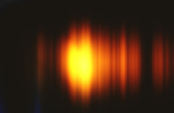 Vibrant streaks of orange and yellow light blending against a dark backdrop, forming an energetic flow and radiant aura