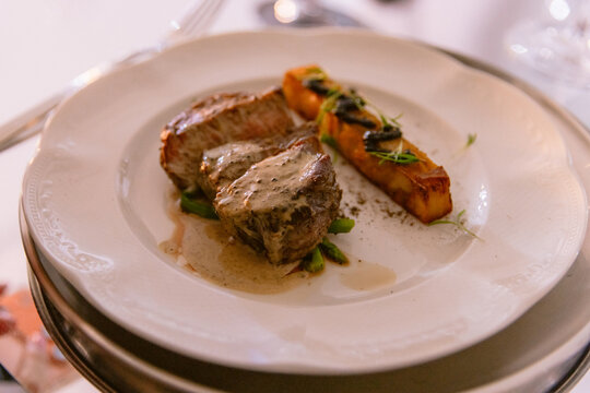 Gourmet plated steak with creamy sauce and roasted vegetables in fine dining restaurant