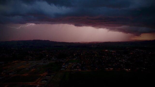 storm/thunder clouds in the evening over a city, soft pink defused light with lightning flashes