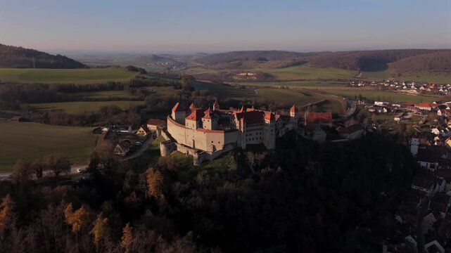 Drone panorama of Harburg Castle on its steep hill overlooking Harburg city and the Woernitz Valley in the Noerdlinger Ries region of Bavaria, Germany during golden hour.