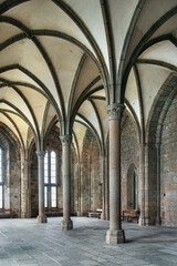 Obraz premium Guest Hall in Mont Saint Michel Abbey, France, interior view. High gothic vaulted stone ceiling and pillars in medieval hall
