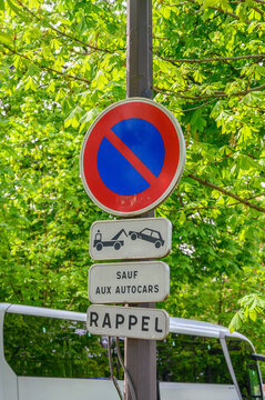 No parking sign with tow away zone and exception for coaches reminder