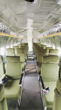 Rows of seats inside an old Soviet military aircraft, green camouflage army seats. Aircraft fuselage ussr. museum