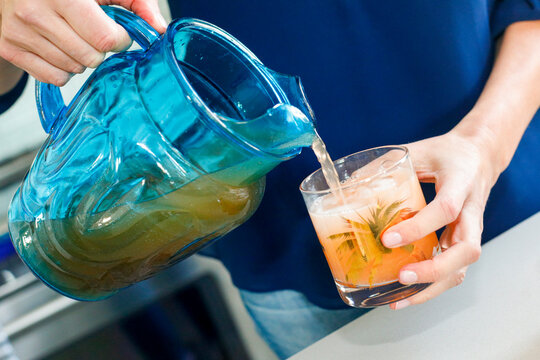 Refreshing orange drink being poured into a cocktail glass