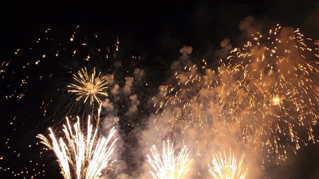 Golden fireworks display at night sparkling pyrotechnic show for celebration festive gold firework explosions in dark sky holiday event background