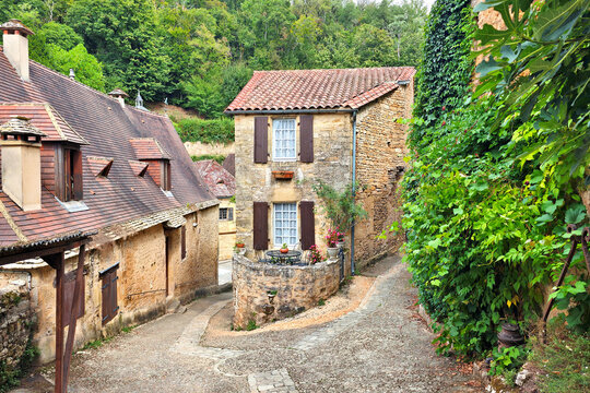 Beautiful cobblestone street in the village of Beynac-et-Cazenac, Dordogne, France with medieval stone houses and climbing vines