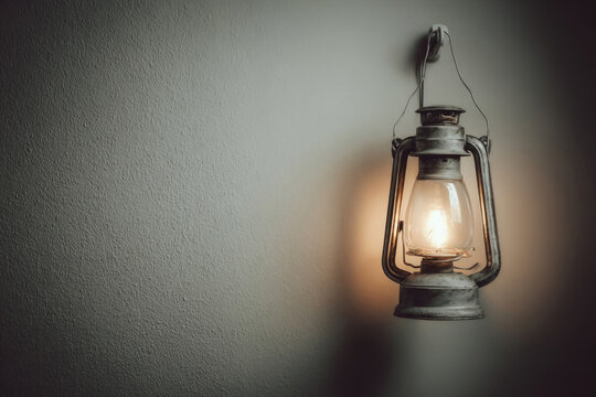 An old metal kerosene lamp on the wall. Space for text.