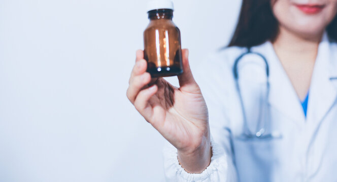 The pharmacist or doctor holding medication or medicine for treatment. Anti biotic pill in the vial.