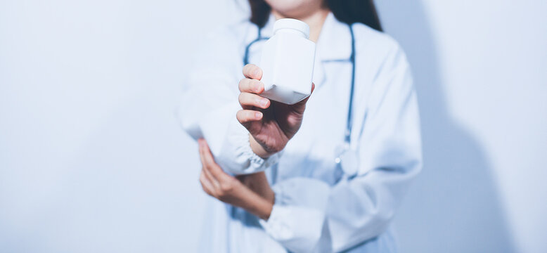 The pharmacist or doctor holding medication or medicine for treatment. Anti biotic pill in the vial.
