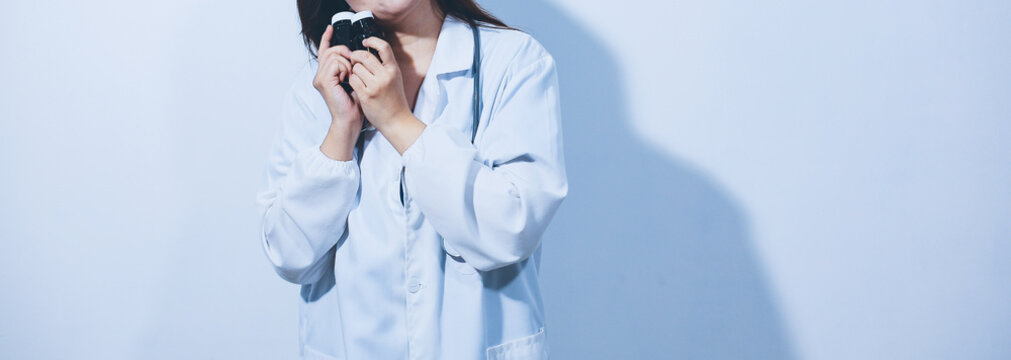 The pharmacist or doctor holding medication or medicine for treatment. Anti biotic pill in the vial.