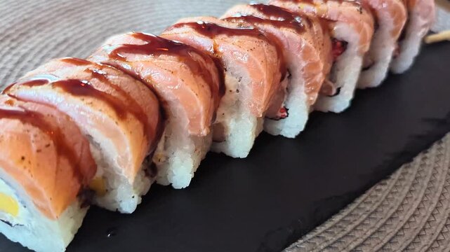 Fresh sushi rolls with fish and rice on black board with vasabi