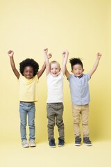 Obraz premium Full length trio of children standing with arms raised