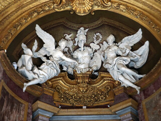 Fototapeta premium Sculture in marmo bianco raffiguranti angeli alati in stile barocco all'interno di una nicchia monumentale con decorazioni e rilievi dorati