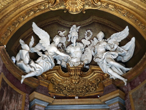 Sculture in marmo bianco raffiguranti angeli alati in stile barocco all'interno di una nicchia monumentale con decorazioni e rilievi dorati